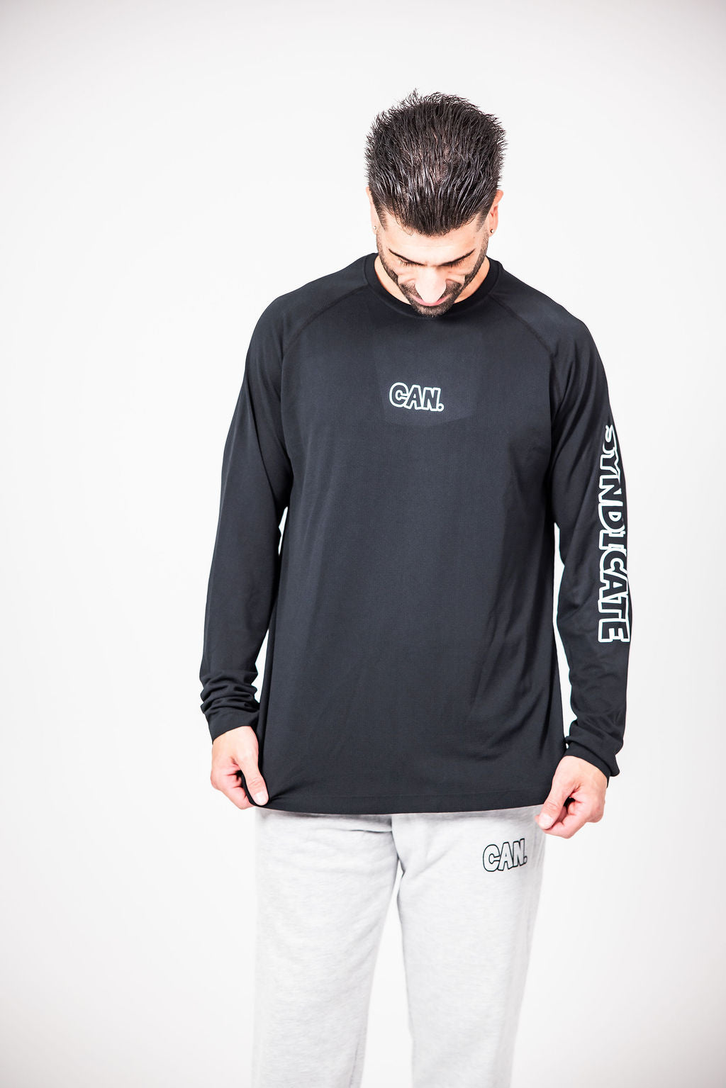 James Webb wearing a CAN. Syndicate Men's Long Sleeve Athletic Tee and CAN. Statement cuffed track pants. 
