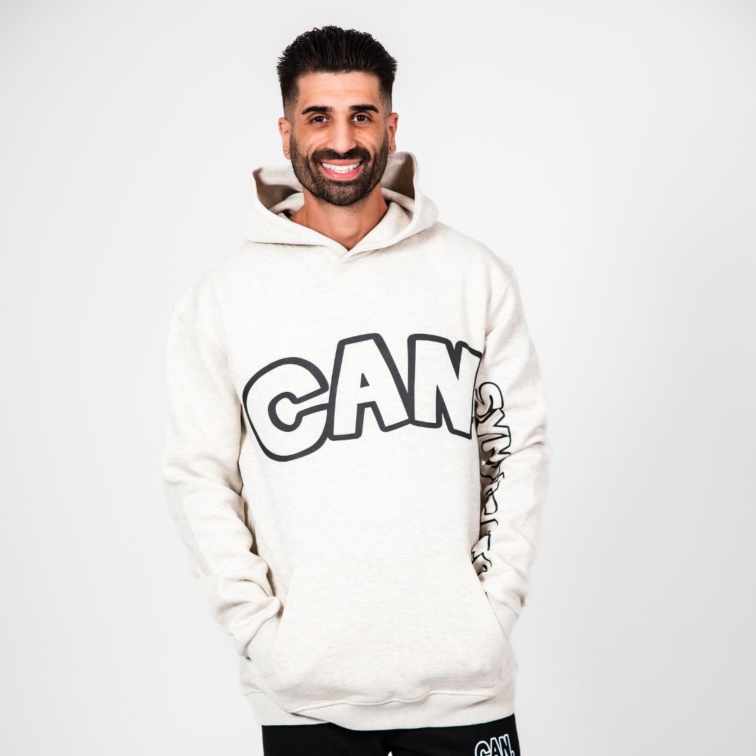 Man wearing a white CAN. Signature Hoodie with 'CAN' printed on it against a white background