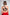Woman wearing black CAN. Syndicate Asymmetrical Cut-Out Crop Top and red track pants facing grey back drop 