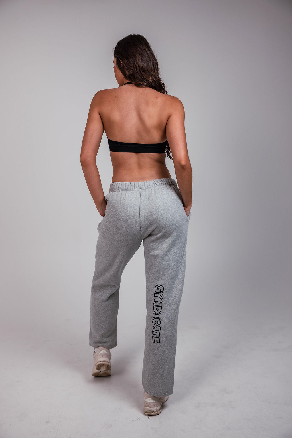 Woman wearing Can. Syndicate Contour Sculpt Crop Top and Can. Syndicate track pants on a white background