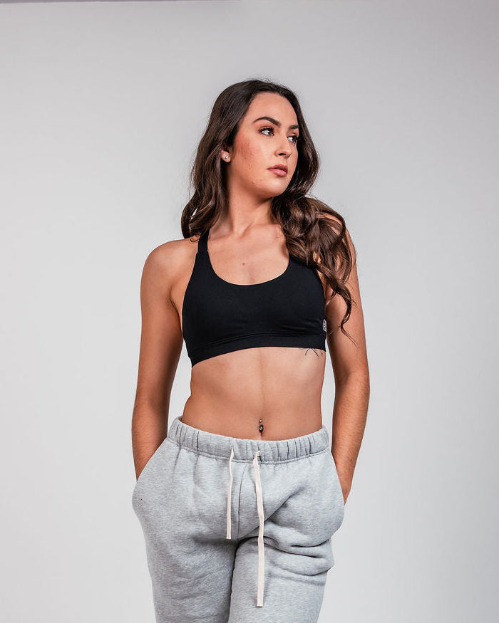 Woman wearing Can. Syndicate Contour Sculpt Crop Top and Can. Syndicate track pants on a white background