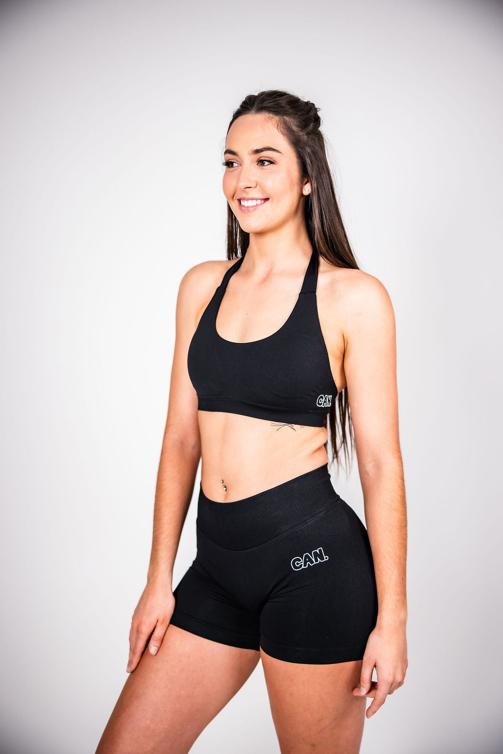 woman wearing black CAN. Syndicate Contour Sculpt Crop top and Can. Syndicate Contour Sculpt Bike Shorts with 'CAN' logos on them. 