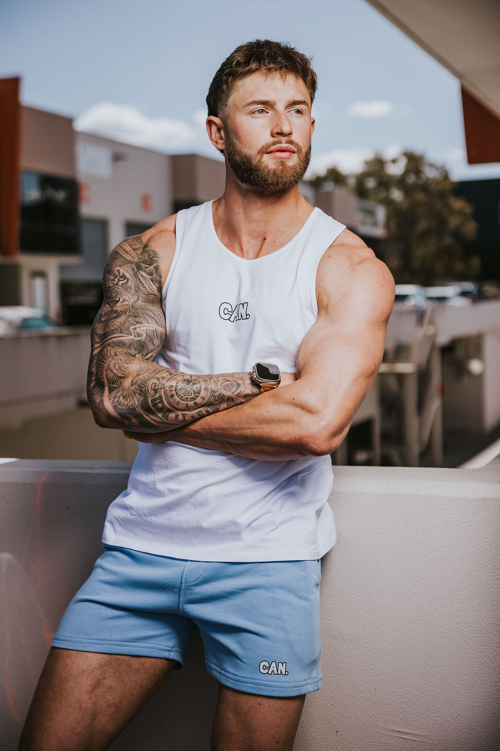 Man wearing CAN. Syndicate Athletic tank top and blue Can. Syndicate Active shorts taken outside during the daytime. 