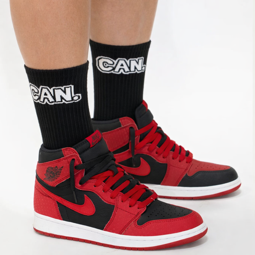 Red and black high-top sneakers with matching socks on a white background