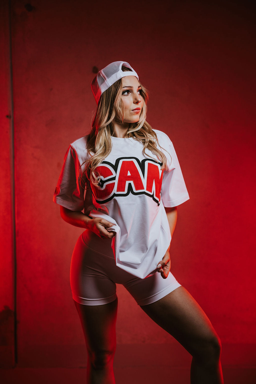 woman wearing a white Can. Syndicate Statement Tee with large "CAN" logo and whiteCAN. Contour sculpt shorts.